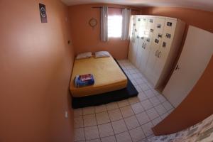 伊瓜苏Casa com varanda próximo da Natureza的小房间,角落里设有一张床
