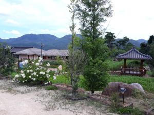 庆州南达月亮旅馆的一个带凉亭和白色鲜花的花园