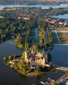 什未林Boulevard Hotel Altstadt Schwerin的水中一座小岛上城堡的空中景观