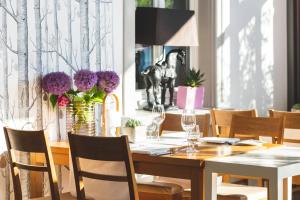 埃夫林根基兴瓦尔赛斯餐厅酒店的用餐室配有木桌、椅子和鲜花