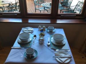 马奇温洛克The Talbot Inn的一张桌子,上面有蓝色的桌布,上面有盘子和餐具