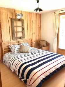波讷地区圣朱利安Chambres d'Hôtes La Téouleyre的一间卧室配有一张带条纹毯子的大床