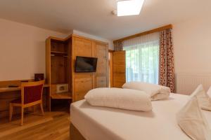 凯撒山麓舍福韦伯保尔酒店的一间卧室配有两张床、一张桌子和一台电视。