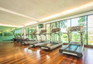 怡保RPGC Garden Hotel的一间铺有木地板的健身房里,有一排跑步机