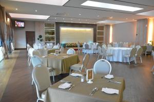 怡保RPGC Garden Hotel的宴会厅配有白色的桌椅和屏幕