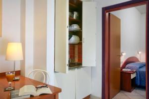 里米尼伊吉拉索里住宅酒店的配有书桌、台灯和书籍的房间
