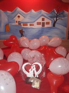 坎波罗索因瓦尔坎纳尔B&B al Buondì的一张桌子,上面有红白气球和一幅房子的画
