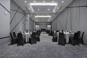 坤甸Hotel Neo Gajah Mada Pontianak by ASTON的一间会议室,配有桌椅和屏幕