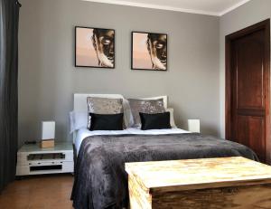 纳萨雷特Canaryislandshost l Tierra的卧室配有一张四幅画的墙壁床。