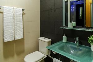 阿马多拉Aquele Cantinho的一间带卫生间、水槽和镜子的浴室