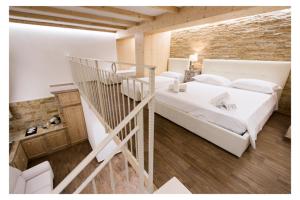 泰尔莫利Ludovica's Apartment的卧室设有一张白色大床和楼梯。
