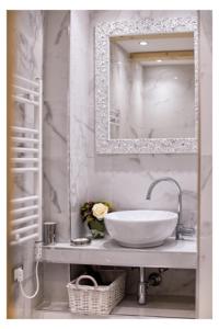 泰尔莫利Ludovica's Apartment的浴室设有白色水槽和镜子