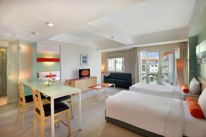 库塔HARRIS Hotel & Residences Riverview Kuta, Bali - Associated HARRIS的酒店客房配有一张床铺、一张桌子和一张书桌。