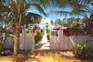 吉汶瓦巴哈蒂酒店的棕榈树和鲜花的白色门