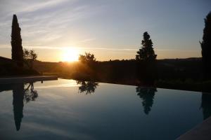 皮恩扎Poggio ai Gelsi的一座享有日落美景的游泳池