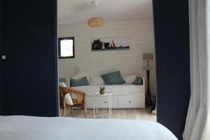 阿拉东Ker Mouettes的一间卧室配有一张床、一张桌子和一张沙发