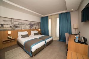 拉巴特拉巴特总站奥诺莫酒店的酒店客房设有两张床和电视。