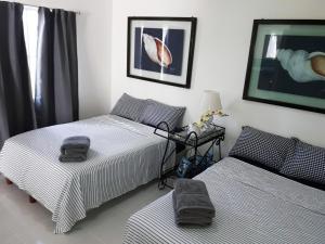 坎昆Cancun Blue Airport的一间卧室配有两张床和一张带台灯的桌子