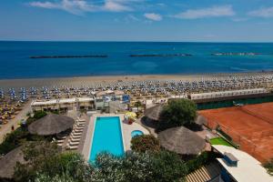 丽都阿德里亚诺Grand Hotel Azzurra Club的享有海滩美景,设有游泳池和遮阳伞