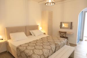 斯希努萨岛Theasis Luxury Suites的一间卧室配有一张床、一张桌子和一面镜子