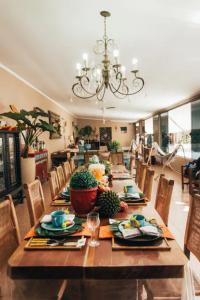 卡纳内亚Pousada Familia Ottoboni的用餐室配有长桌子、椅子和吊灯