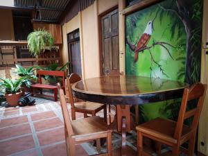 蒙泰韦尔德哥斯达黎加Greemount Hotel的餐桌,椅子和墙上的鸟
