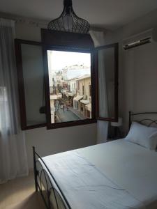 Áyios AndóniosProkymaia Apartment 2的一间卧室设有一张床和一个大窗户