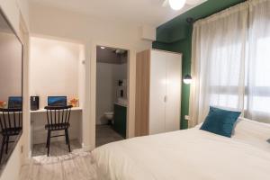 耶路撒冷戈尔道度假租赁公寓的一间卧室配有一张床、一张桌子和一把椅子