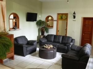 马萨米特拉埃尔莱纳多酒店的客厅配有黑色皮革家具和电视