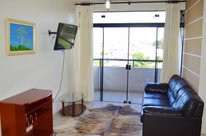 普鲁登特总统城罗塔多潘塔纳尔酒店的客厅配有真皮沙发和电视