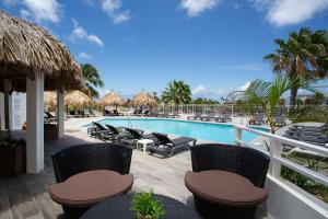 威廉斯塔德库拉索比尼盂兰盆海滨度假胜地的一个带椅子和遮阳伞的游泳池的度假酒店