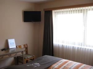 策尔内茨塞尔瓦比萨店酒店的一间卧室配有一张床、一张书桌和一个窗户。