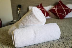 埃默拉尔德翡翠公园汽车旅馆 的床上的白色毛巾堆