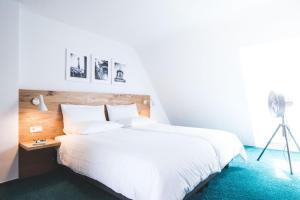 乌尔姆乌尔姆明斯特酒店的卧室配有白色大床和三角架