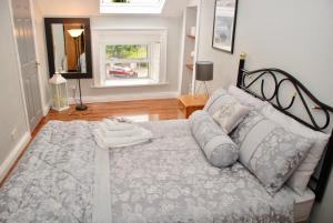 朗福德Tranquility的卧室配有带枕头的大床和窗户。