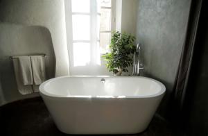 圣保罗-德旺斯la maison aux bonsais的带窗户的浴室内的白色浴缸