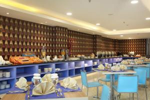 查亚普拉Horison Express Sentani的一间设有蓝色桌椅的餐厅和一间厨房