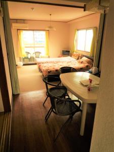 伊势市Futami Terrace B的卧室配有一张床和一张桌子及椅子