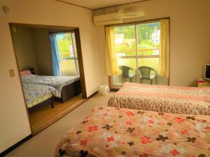 伊势市Futami Terrace B的一间卧室设有两张床和窗户。