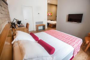科尔多瓦桑普奇诺苏活精品Spa酒店的一间卧室配有一张带红色枕头的床