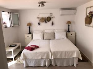 EsteponaEstudio a 10 minutos del Puerto Banus的卧室配有白色的床单和枕头