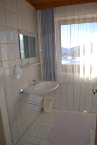 拉德施塔特因维特勒贝尔格宾馆的白色的浴室设有水槽和窗户。