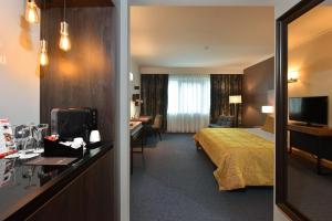 亨法尔马丁迪拉克城堡酒店的酒店客房配有一张床和一张书桌及一台电视