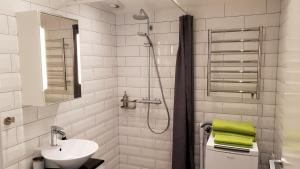 隆德PAX Apartments的白色的浴室设有水槽和淋浴。