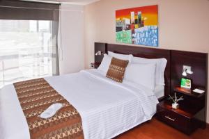 波哥大Aparta-Suites Mirador del Recuerdo的卧室设有一张大白色的床和大窗户