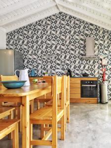 马达莱纳Casa do Sal的厨房配有木桌、椅子和墙壁