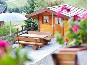 托特瑙贝格Haus Keller Ferienwohnungen的小木屋配有野餐桌和雨伞