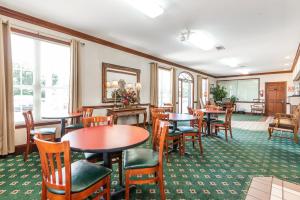 米灵顿种植橡树酒店的餐厅设有桌椅和窗户。