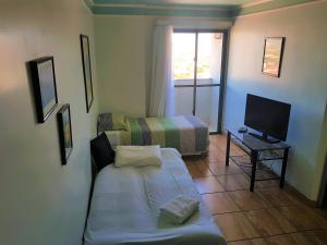 巴乌鲁Flat Saint Paul Residence的小房间设有床和电视