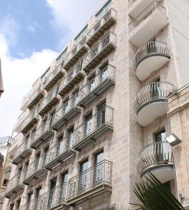 耶路撒冷亚瑟酒店 - 阿特拉斯精品酒店的公寓大楼的一侧设有阳台。